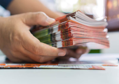 Someone holding a stack of freshly printed brochures