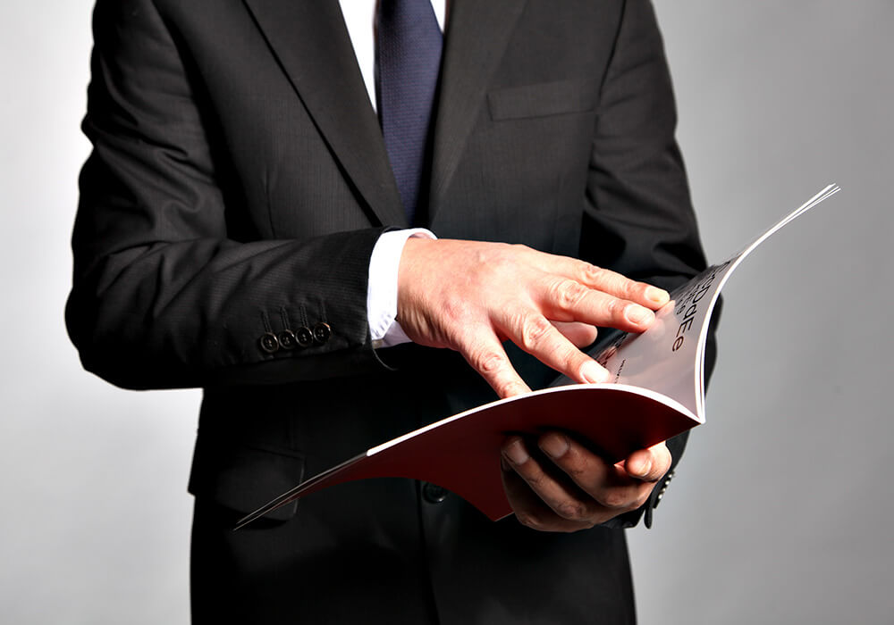 Businessman Holding a Freshly Printed Booklet
