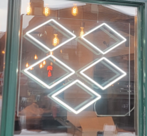 A custom white faux neon LED sign of the Dropbox company logo