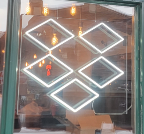 A custom white faux neon LED sign of the Dropbox company logo